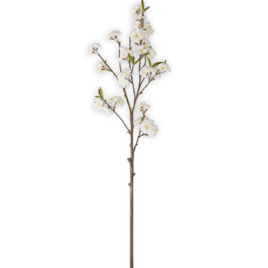 Artificial cherry blossom branch with white flowers on a white background