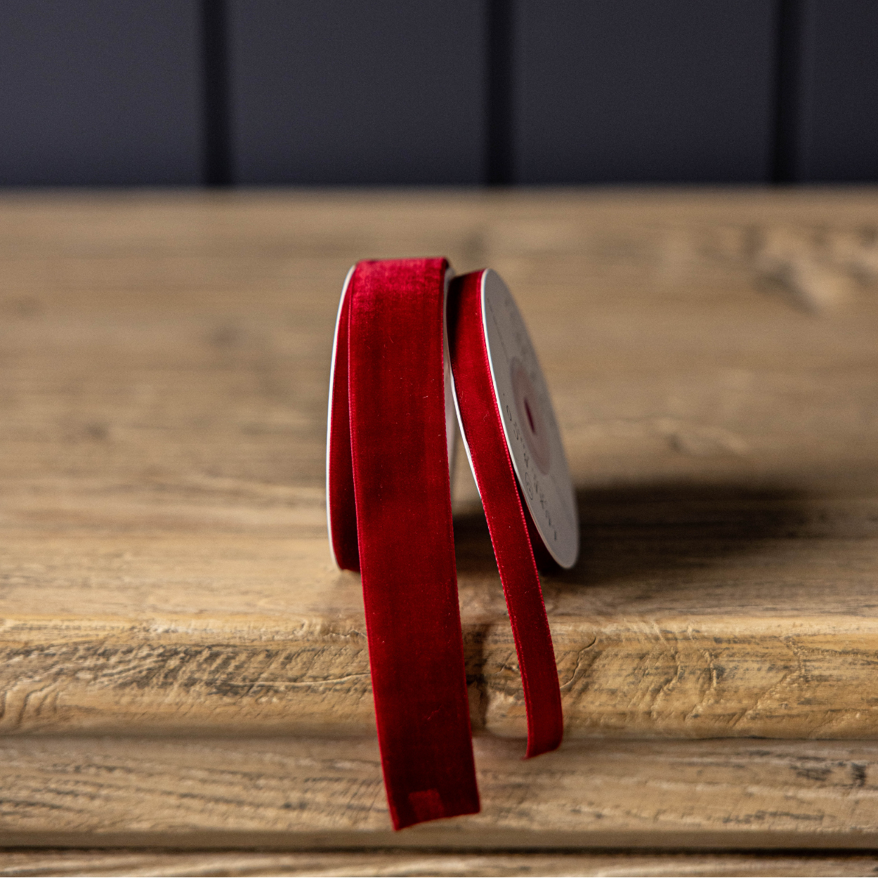 Red ribbon on a wooden surface with a dark background