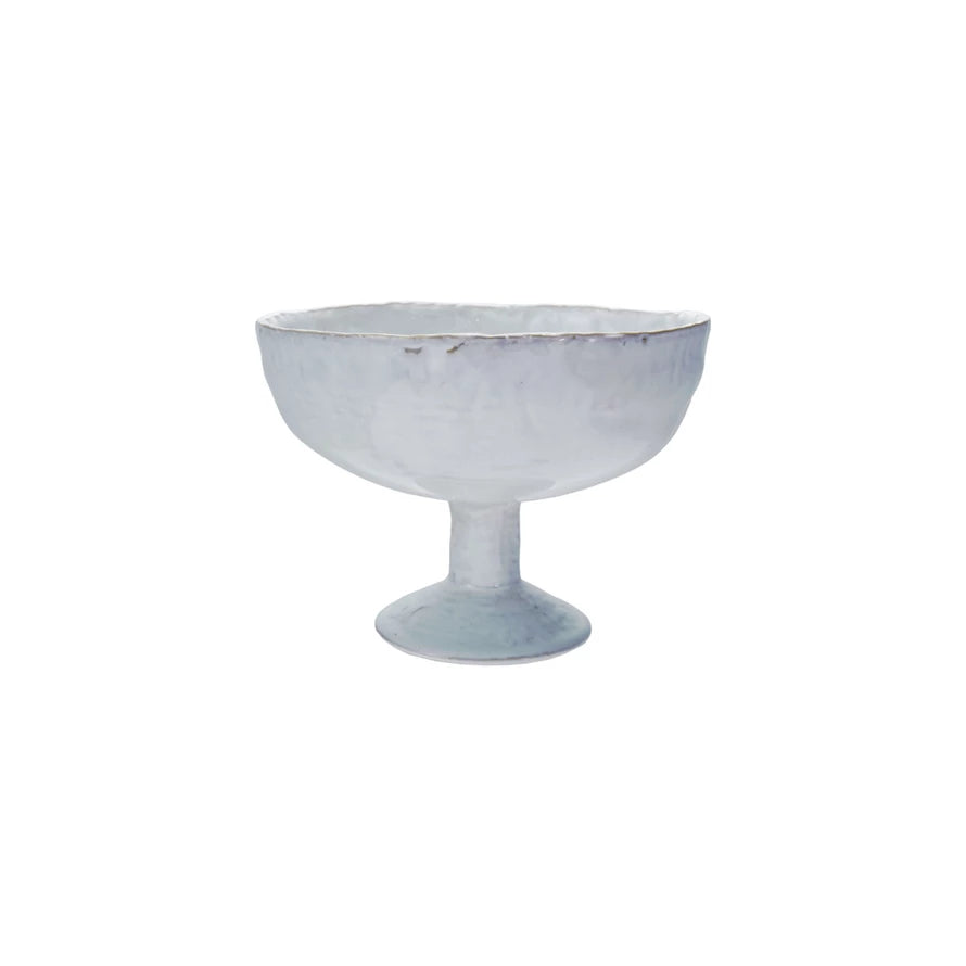 A white stoneware footed bowl with a reactive crackle glaze