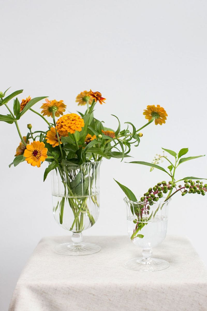 APRIL VASE - Mouth Blown Glass Vase from Evolution Home Decor. Shown Styled with Beautiful flower bouquet. The white and Yellow glass bring out the vibrant colors of the flowers.