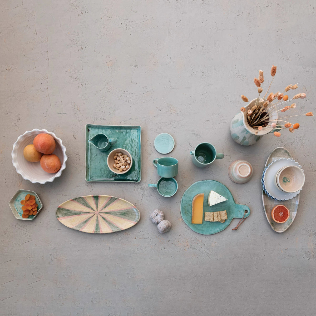 A set of stoneware bowls with scalloped edges, displayed in three colors: white, green, and blue.