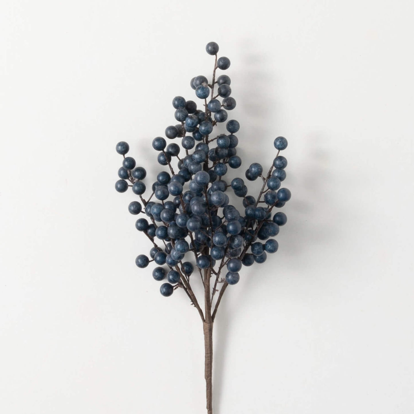 A spray of artificial blue blueberries for use in floral arrangements.