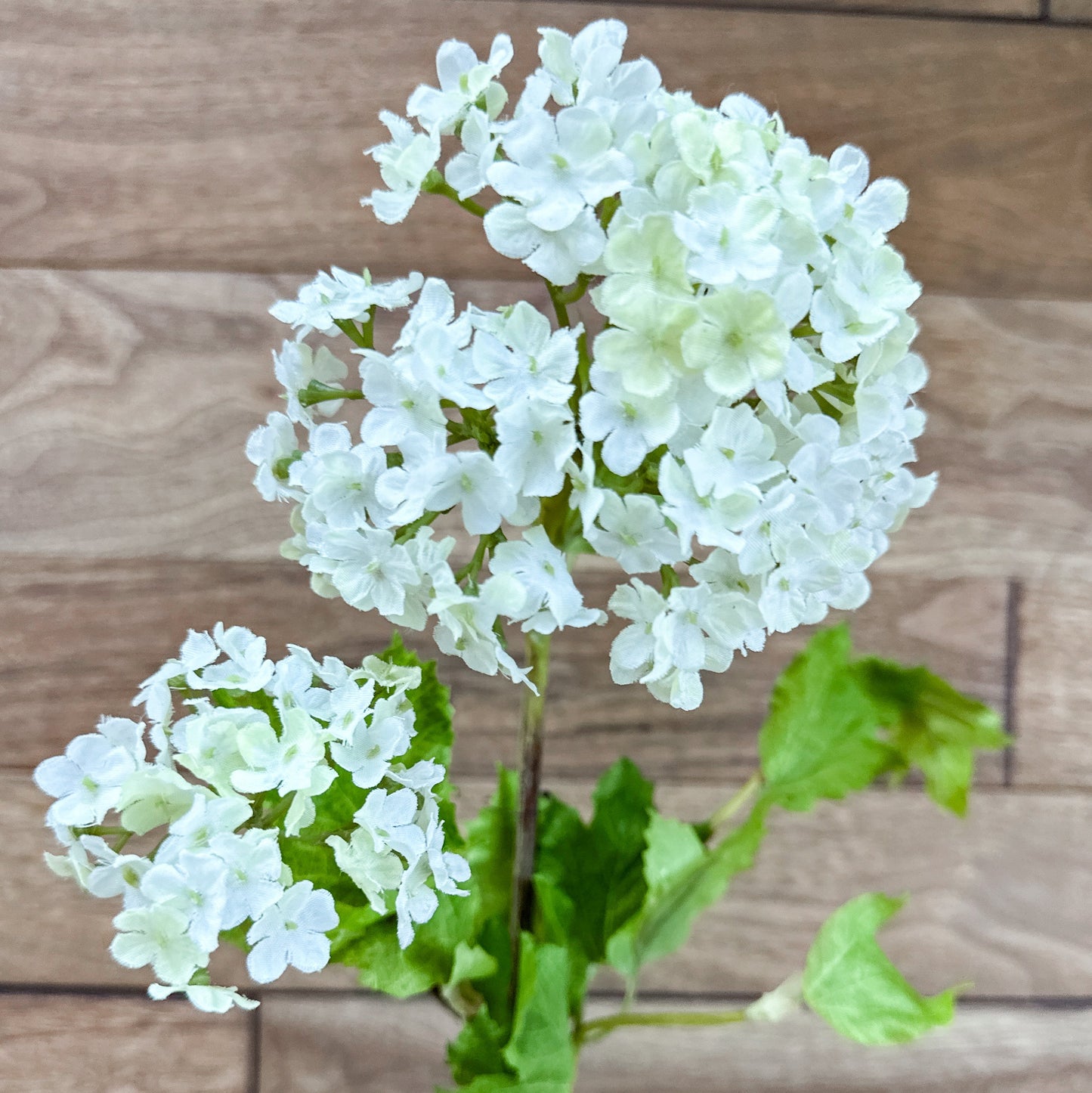 Artificial white flowers with green leaves on a wooden background 32" White Snowball 2 Bloom Hydrangea Stem Spray