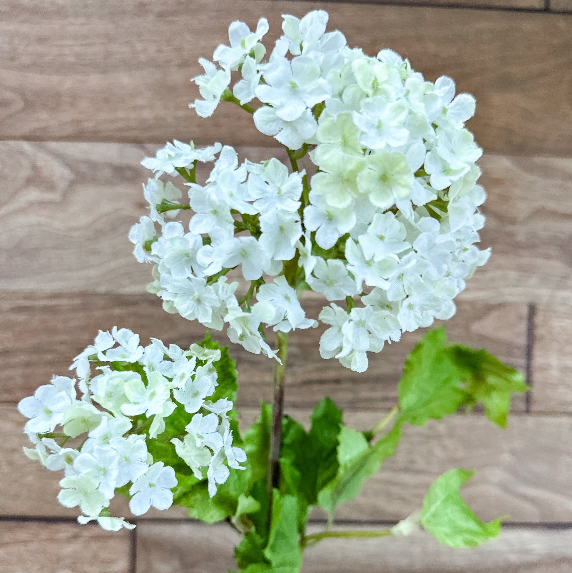 Artificial white flowers with green leaves on a wooden background 32" White Snowball 2 Bloom Hydrangea Stem Spray