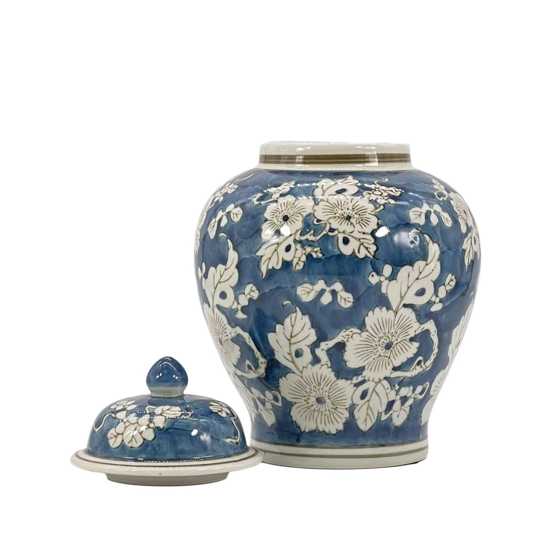 Blue ceramic jar with white floral patterns on a white background