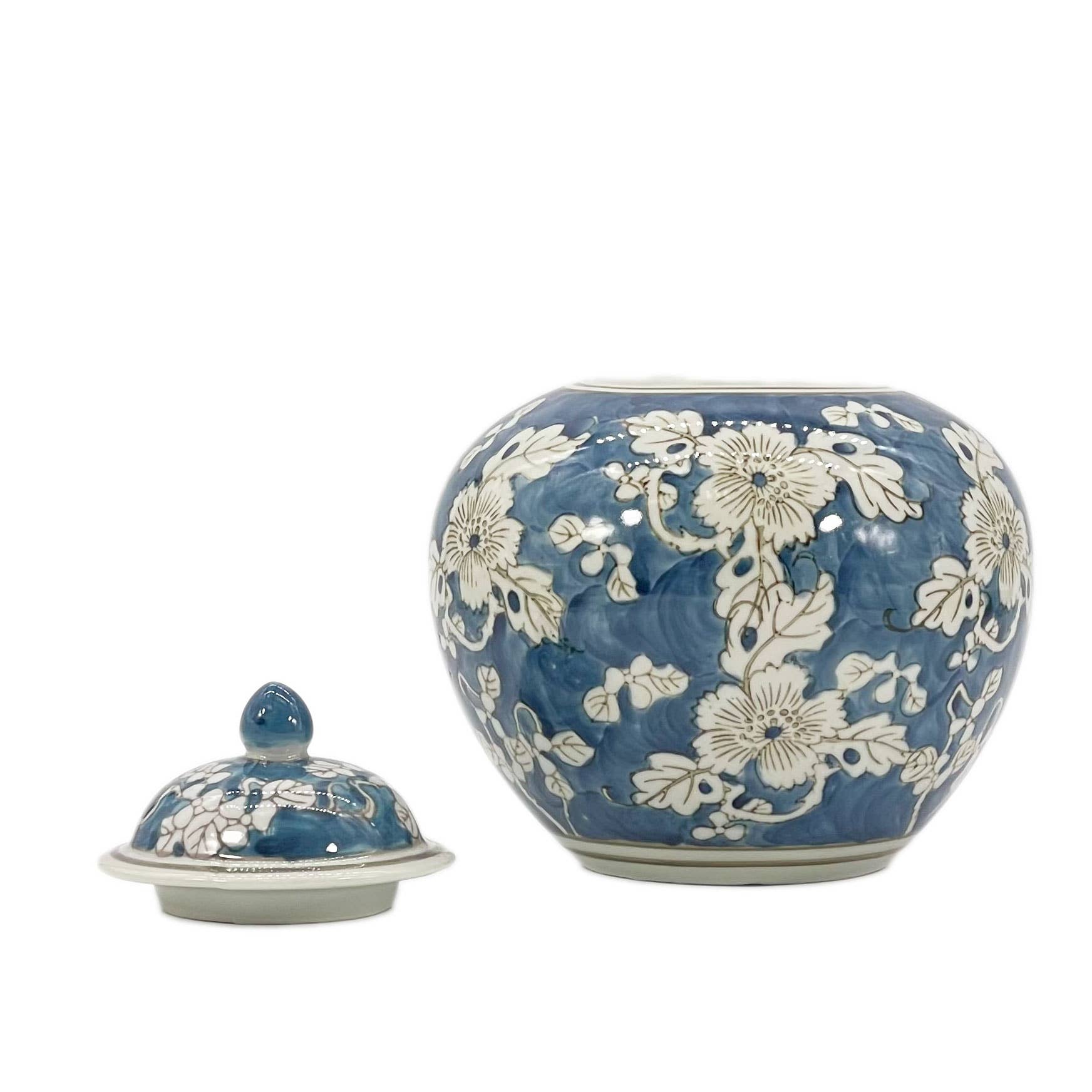 Blue ceramic jar with white floral patterns on a white background