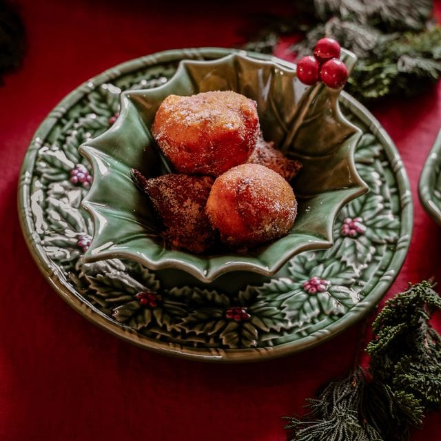 Decorative ceramic plate with roasted chestnuts on a red surface
