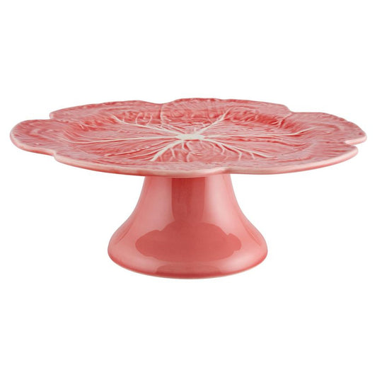 Pink ceramic cake stand with cabbage leaf design on a white background