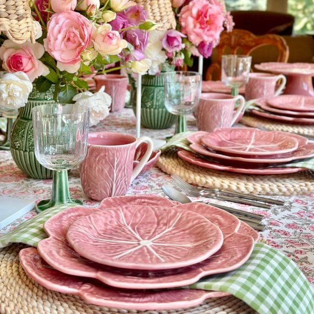 Pink tableware set with floral arrangements on a decorated table