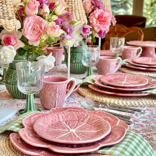 Pink tableware set with floral arrangements on a decorated table