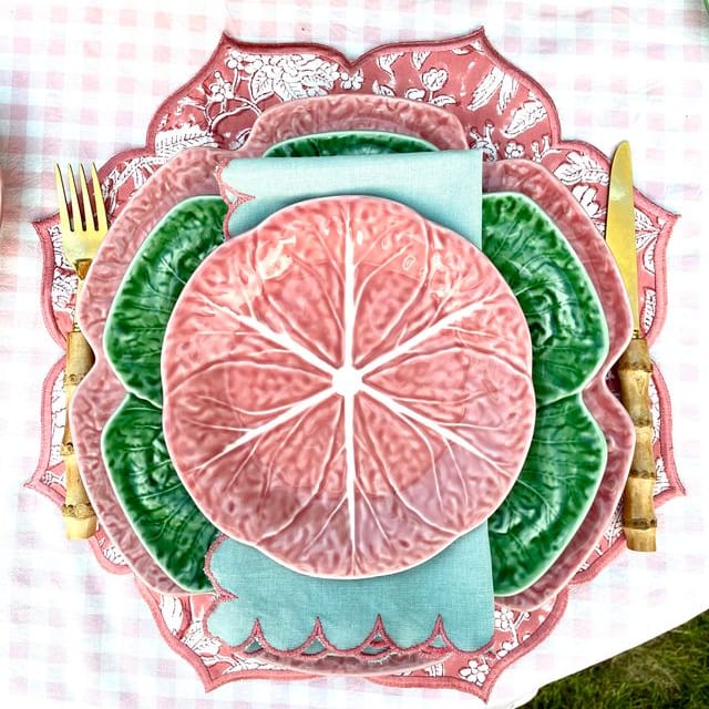 Decorative plate with pink cabbage leaf design on a checkered tablecloth