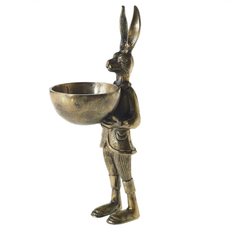 A brass-gold finished metal stand in the shape of a rabbit holding a bowl.