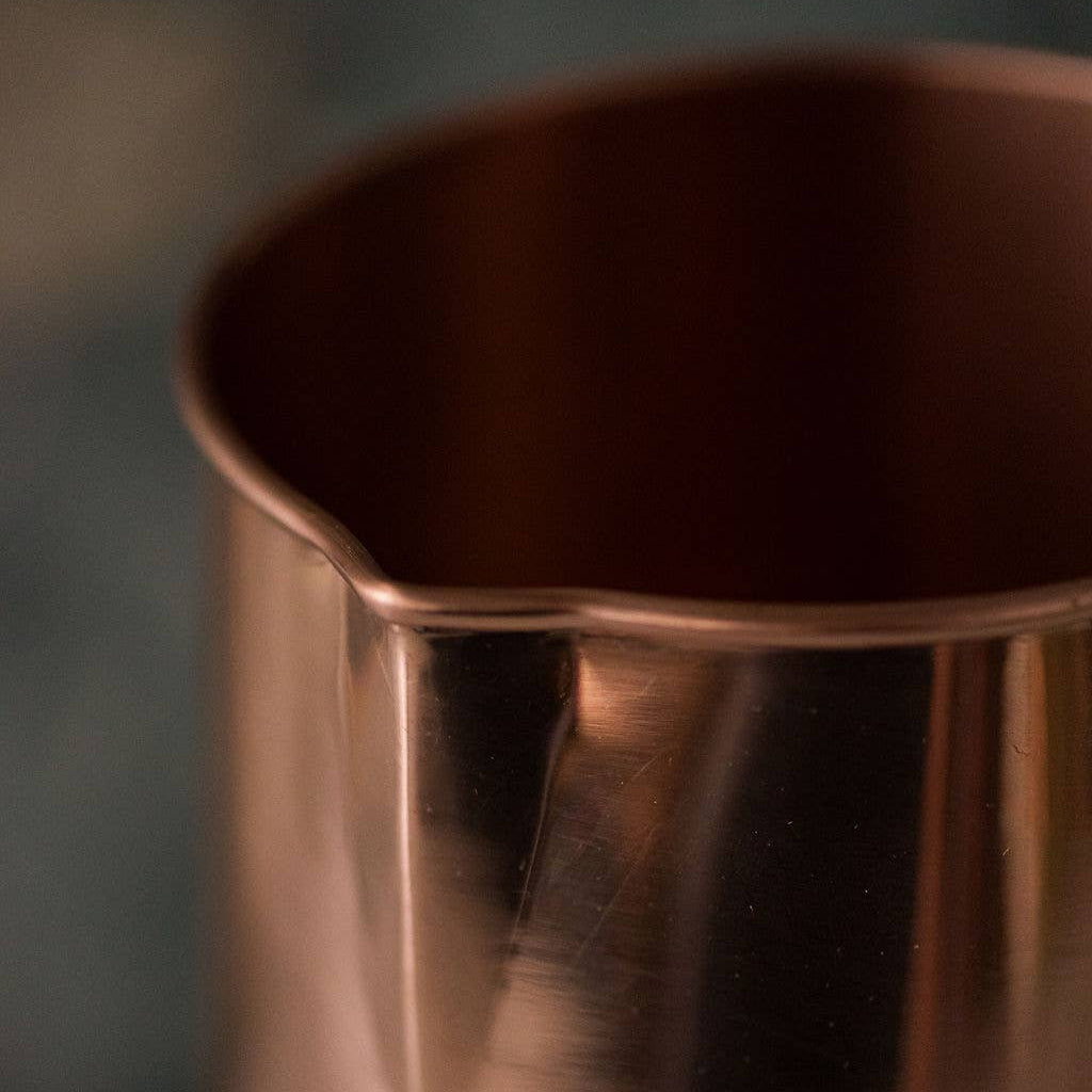 Close-up of a copper pitcher with a blurred background