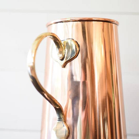 Copper pitcher with a handle on a white background