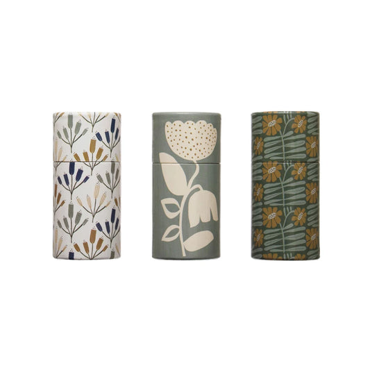 Three cylindrical tube matchboxes, each with a different floral pattern design.