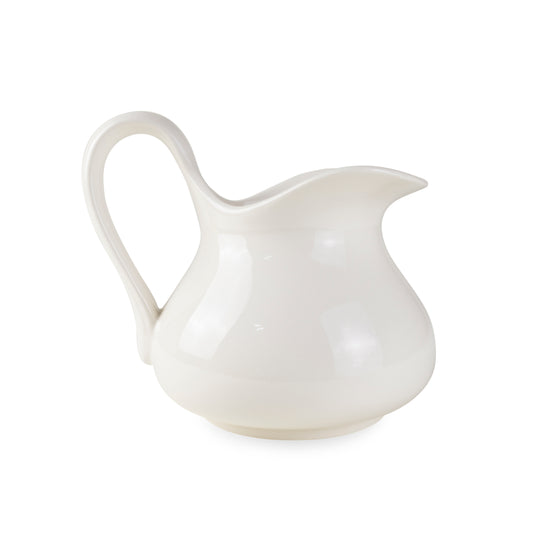 A white ceramic pitcher with a smooth glossy finish, hand-carved with a handle on the side.