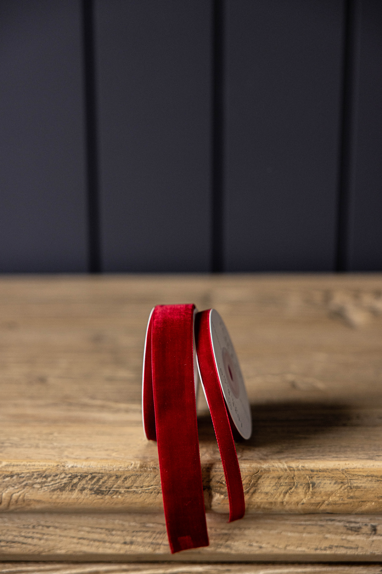 Red ribbon on a wooden surface with a dark background