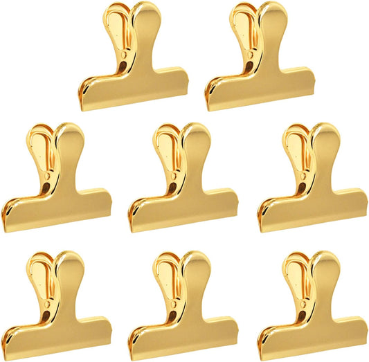 A collection of gold-colored stainless steel clips arranged in a group.
