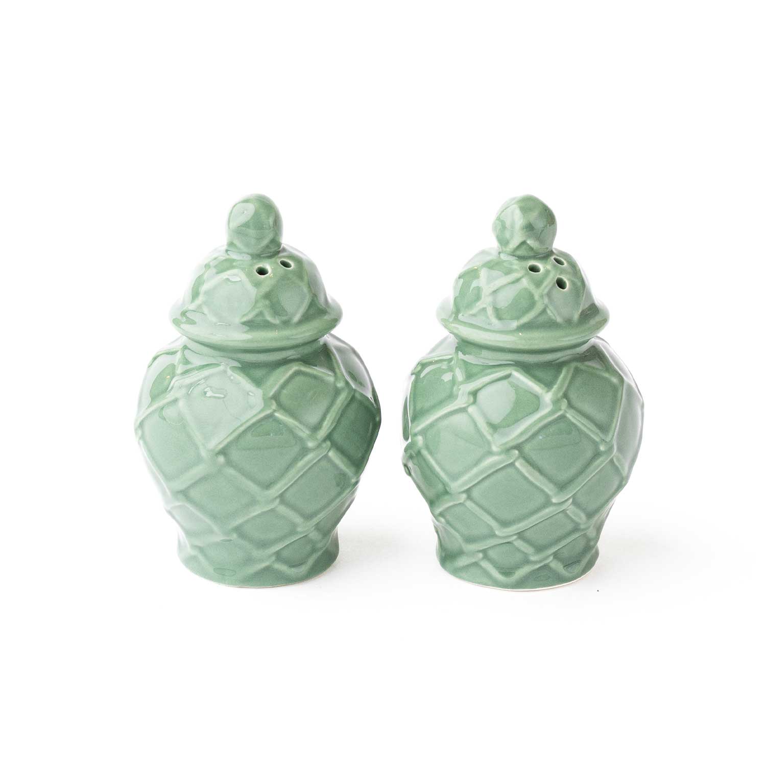Pair of green ceramic salt and pepper shakers on a white background