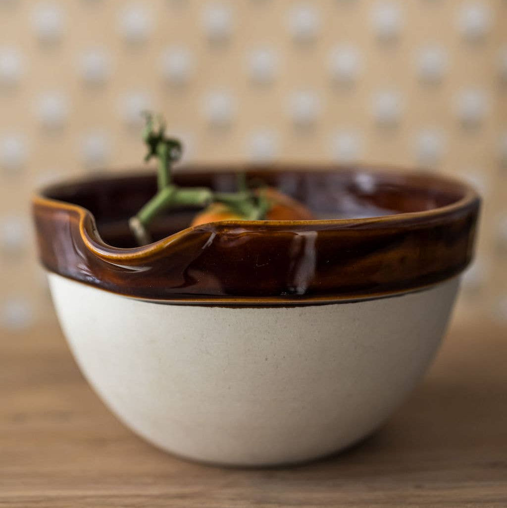 Ceramic bowl with brown rim on a wooden surface