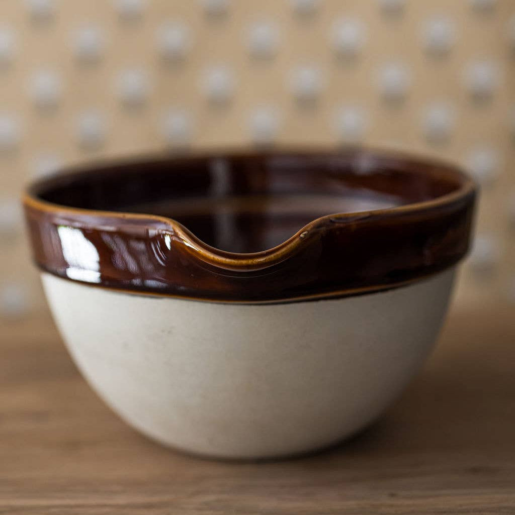 Ceramic bowl with brown rim on a wooden surface
