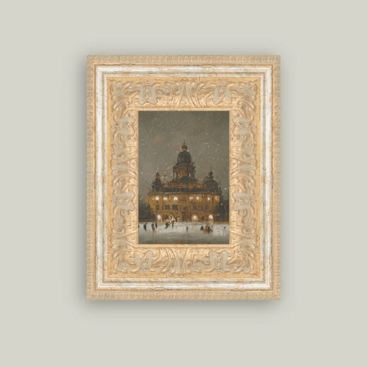 Framed artwork of a illuminated building at night on a light gray wall.