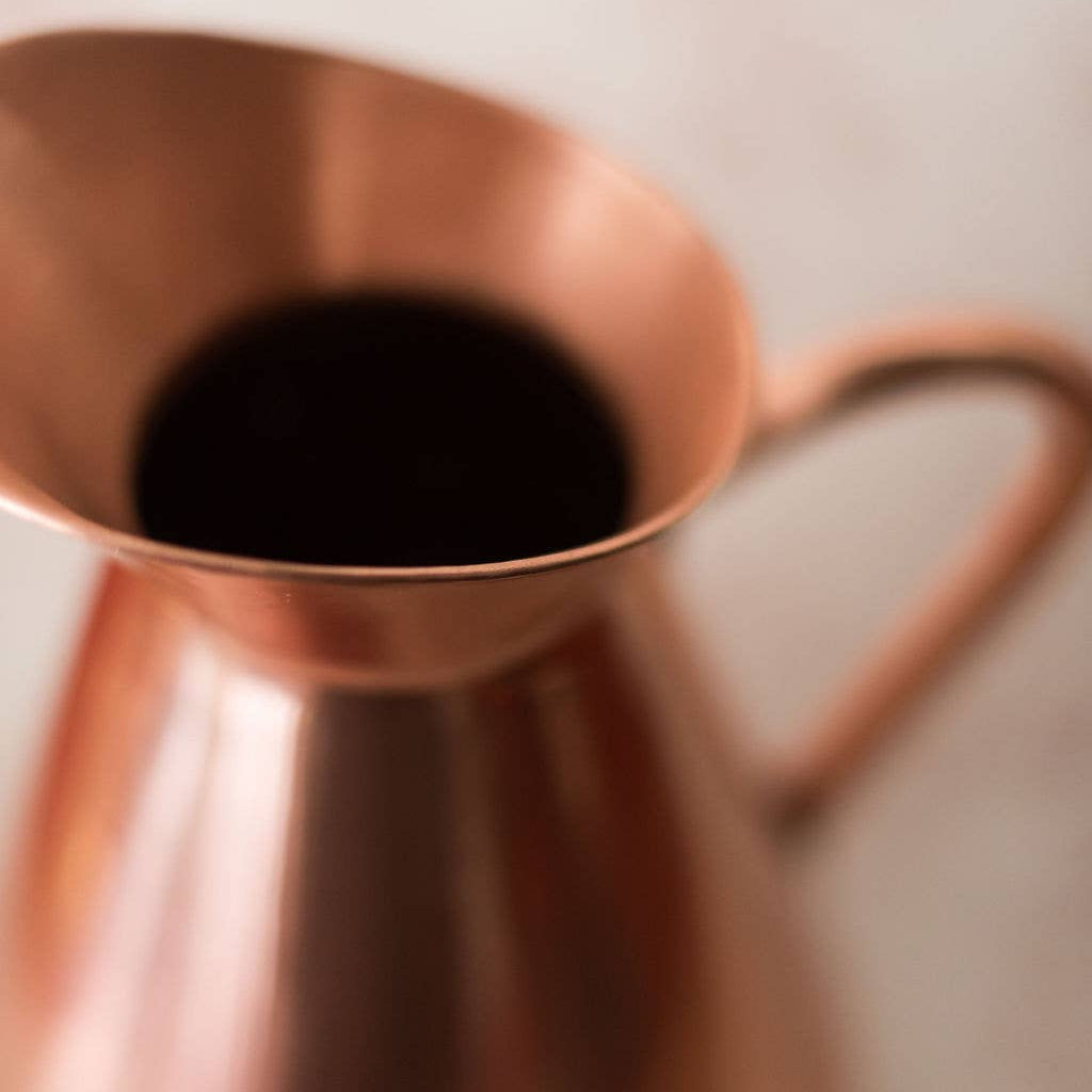 Copper pitcher on a light background