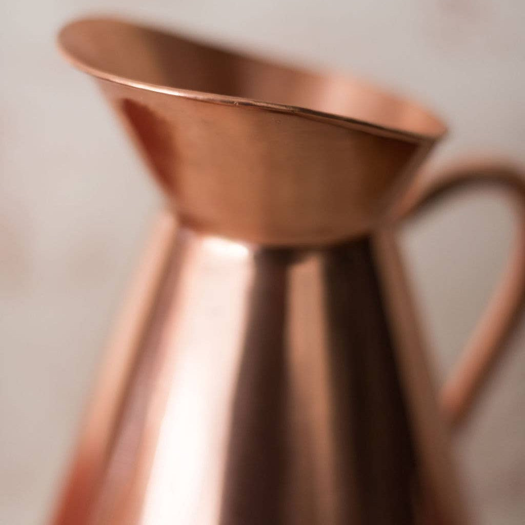 Close-up of a copper pitcher with a blurred background