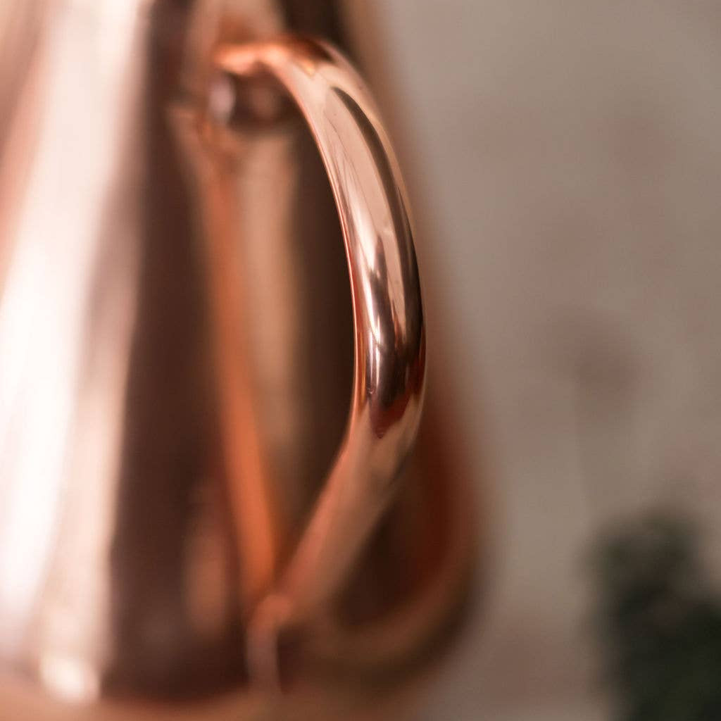 Close-up of a copper pitcher with a blurred background