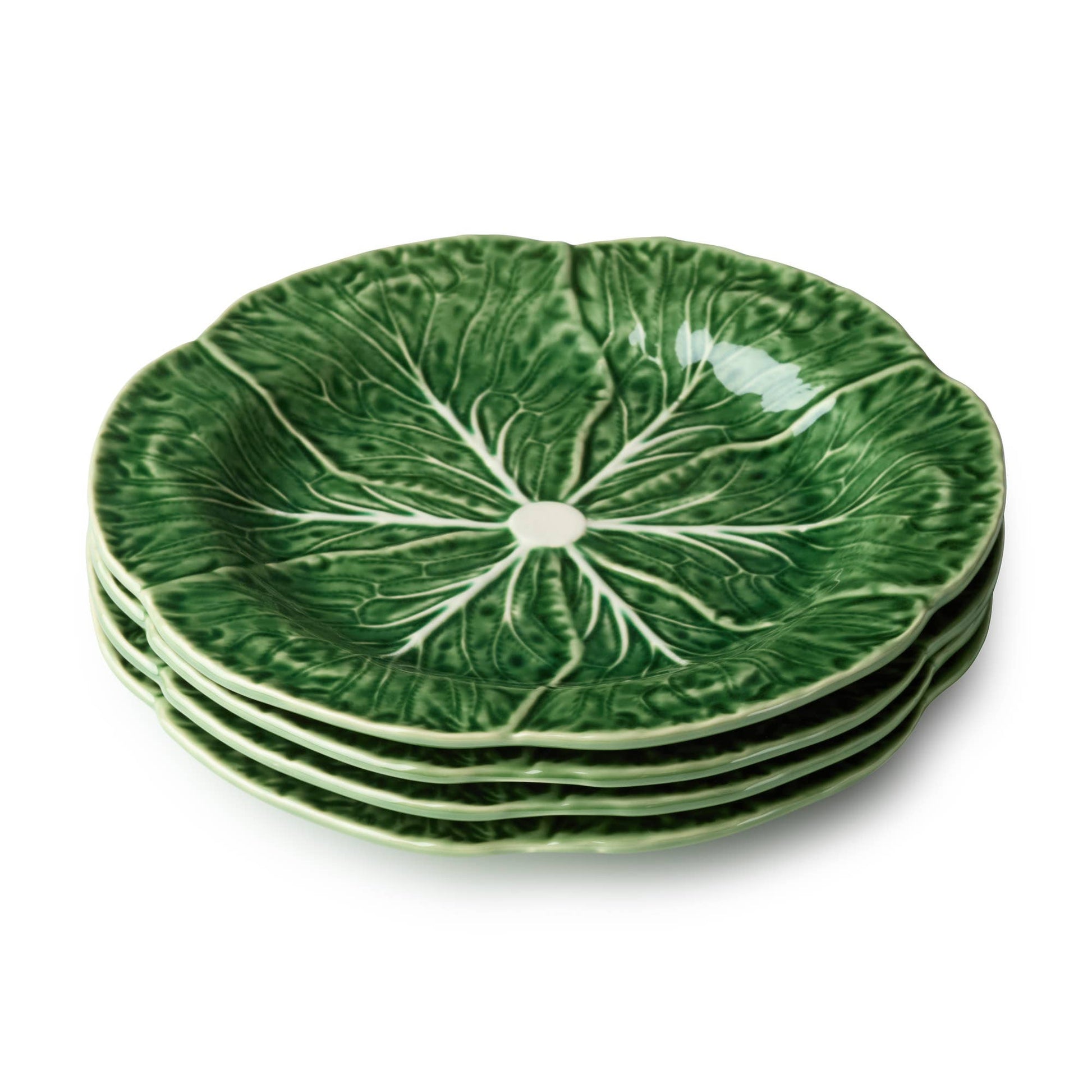 Stack of green ceramic plates with leaf pattern on a white background