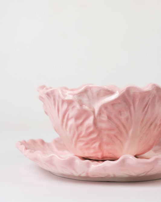 Pink ceramic cabbage leaf bowl with textured surface on a light gray background