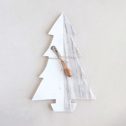 A marble cheese/cutting board in the shape of a Christmas tree with a metal canape knife placed on it, set against a neutral background.