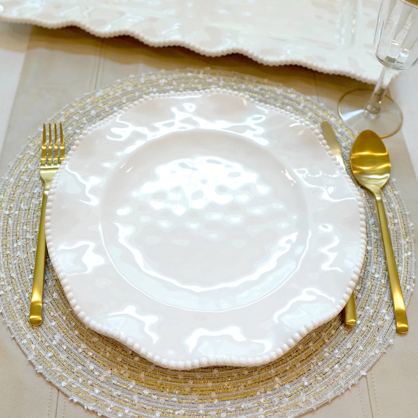 White melamine 11" plate with gold cutlery on a decorative placemat