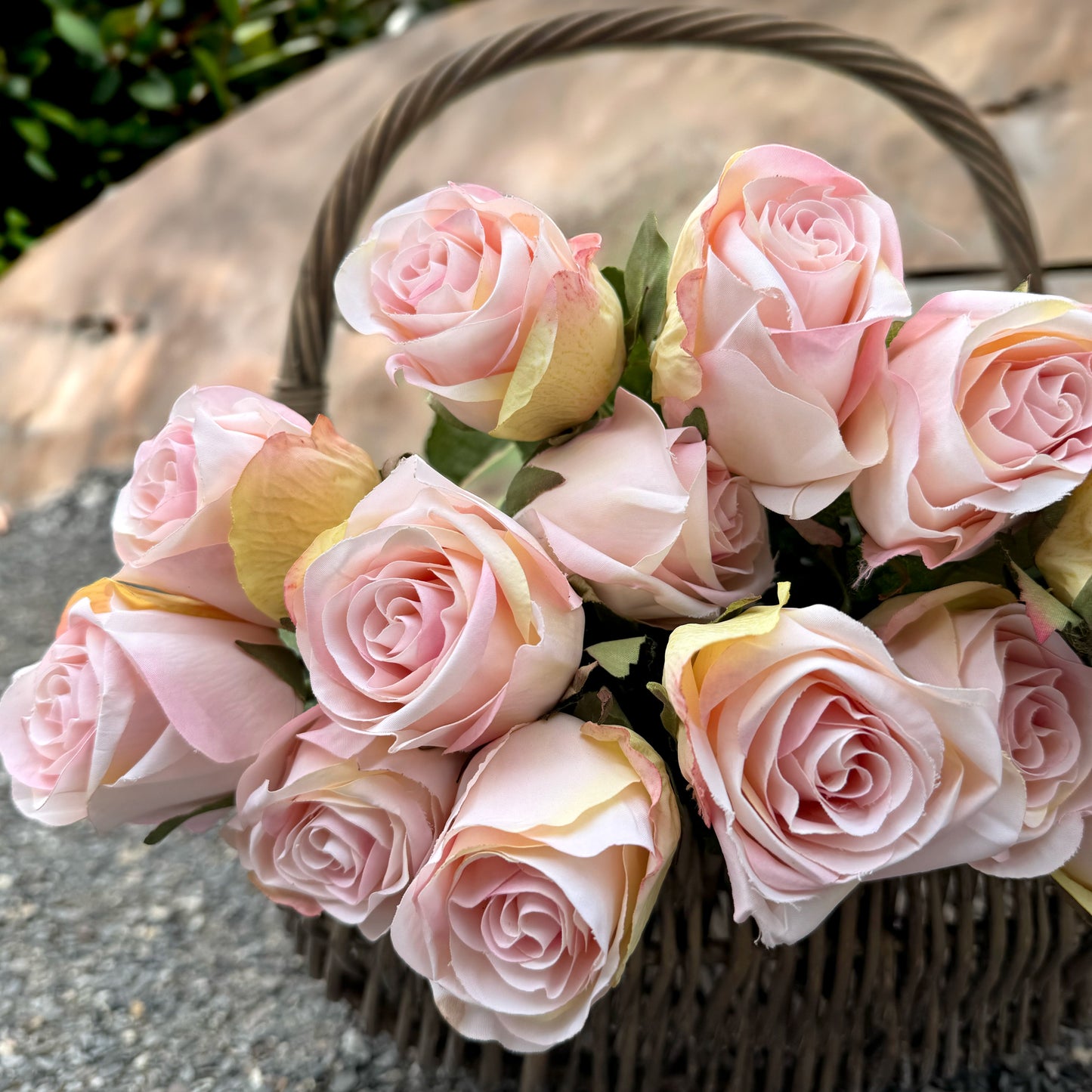 Basket of pink roses on a stone surface
