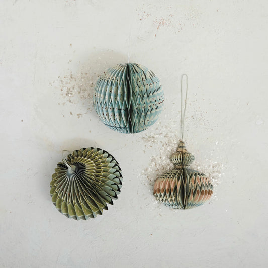 Three round paper folding honeycomb ornaments with multicolor patterns, laid out on a flat surface.