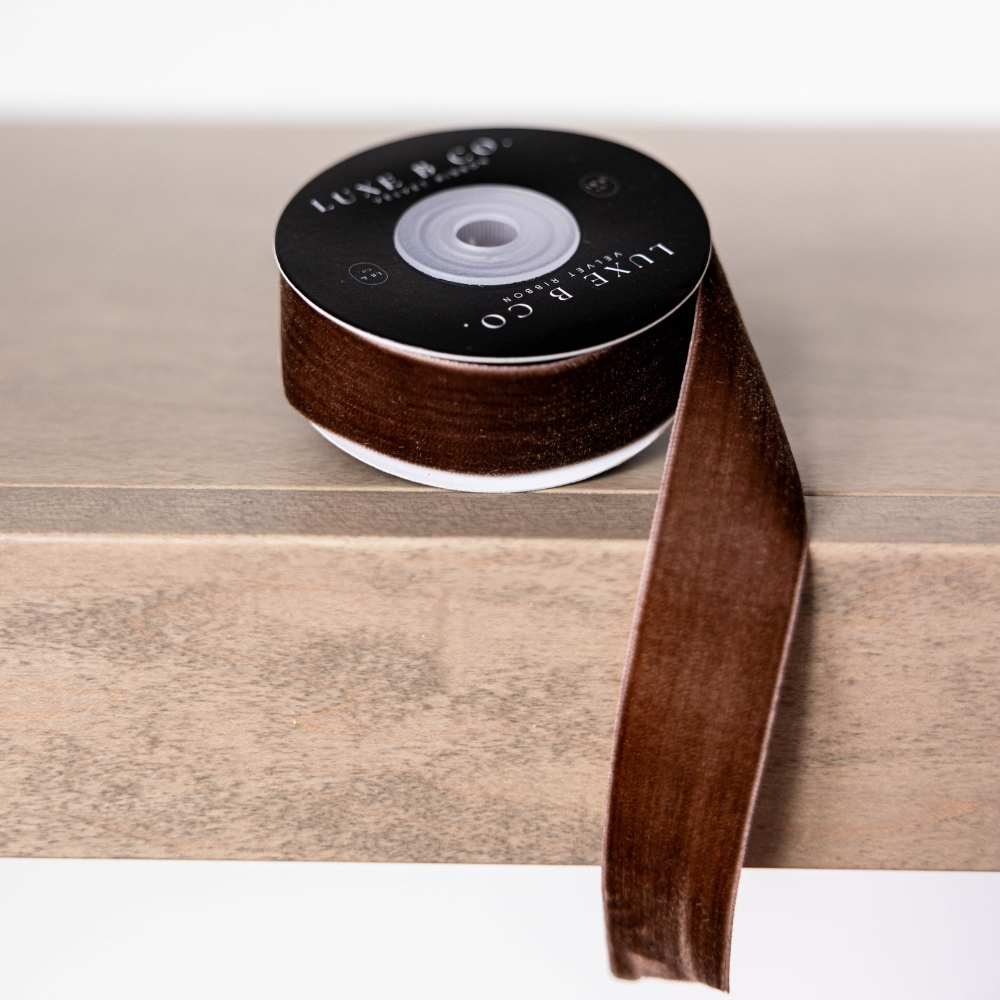 Brown ribbon spool with visible branding on a wooden surface
