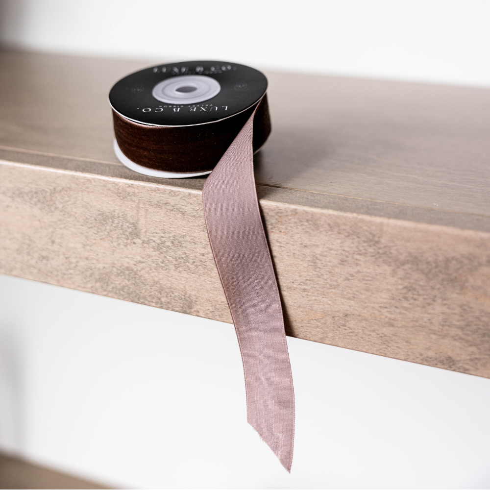 Spool of ribbon on a wooden surface with a white background