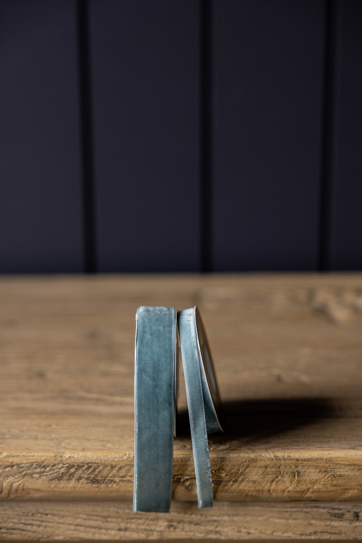Two blue coasters on a wooden surface with a dark background