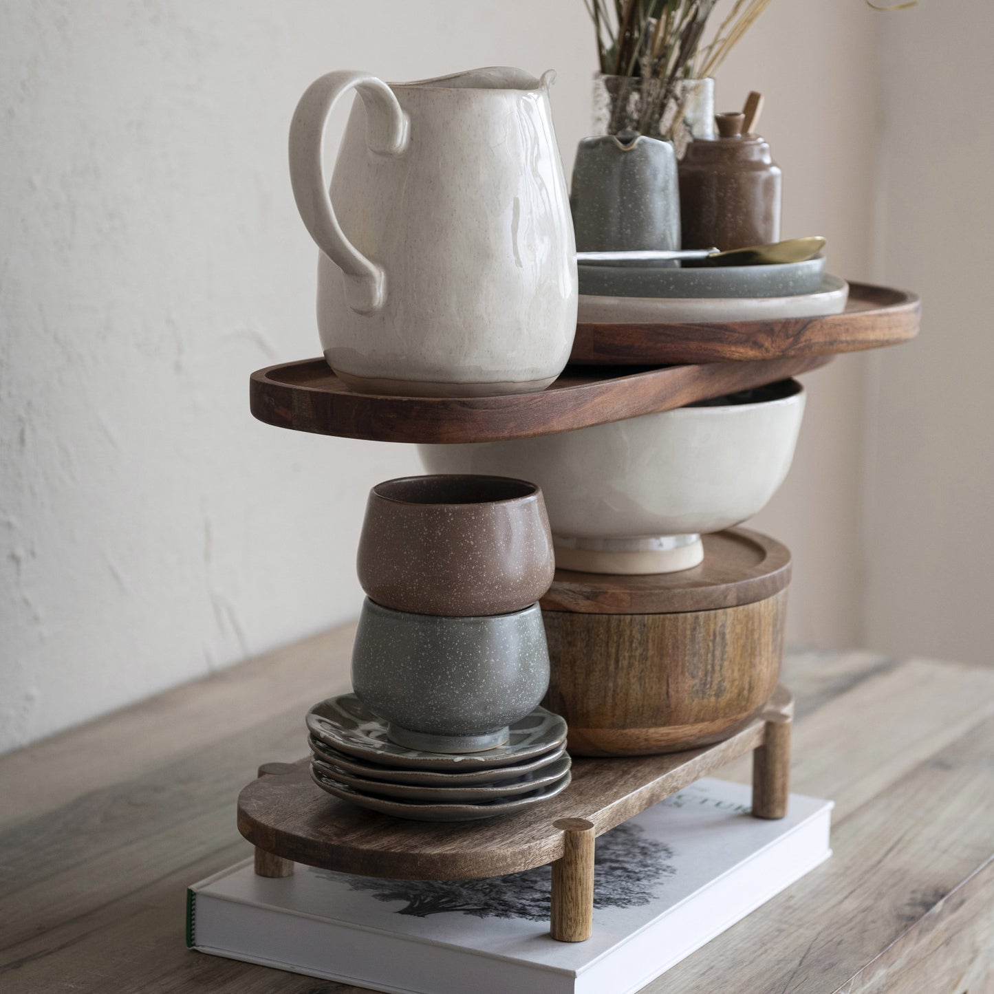 Wooden shelf with ceramic bowls and a pitcher on a wooden surface.