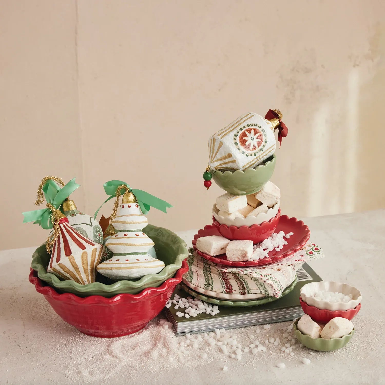 Decorative Christmas scene with stoneware bowls and ornaments on a textured surface.