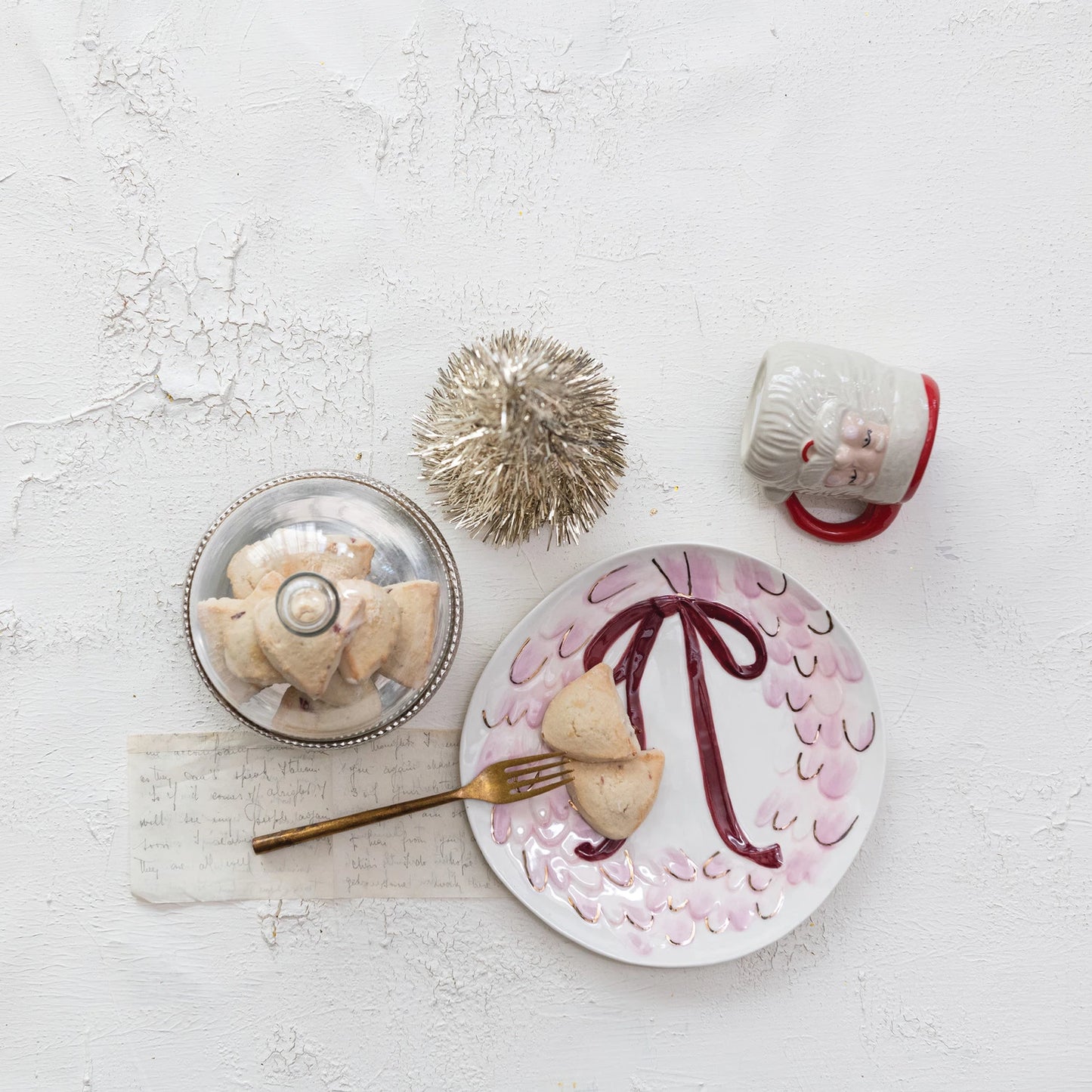 Decorative plate with a design, a small dish, a fork, and a decorative item on a light background