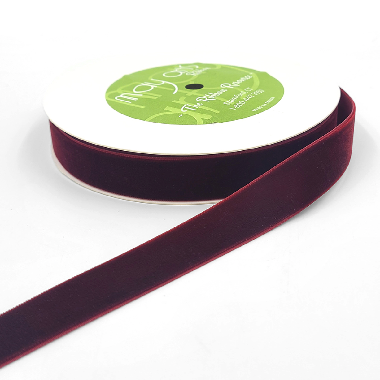 A roll of burgundy velvet ribbon with woven edge