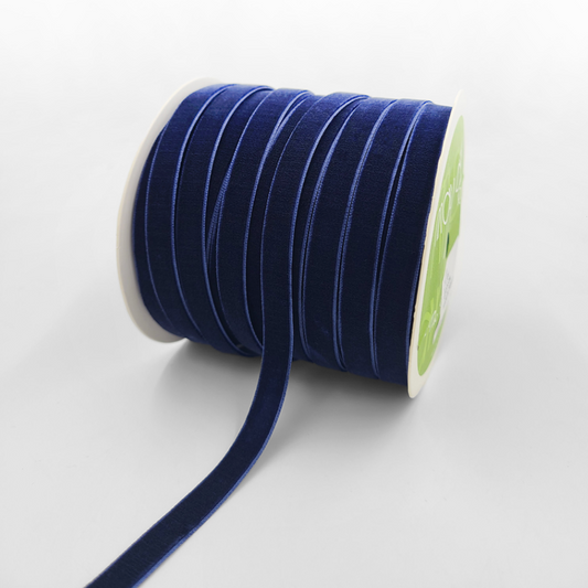 A roll of navy blue velvet ribbon with woven edge, displayed on a white background.