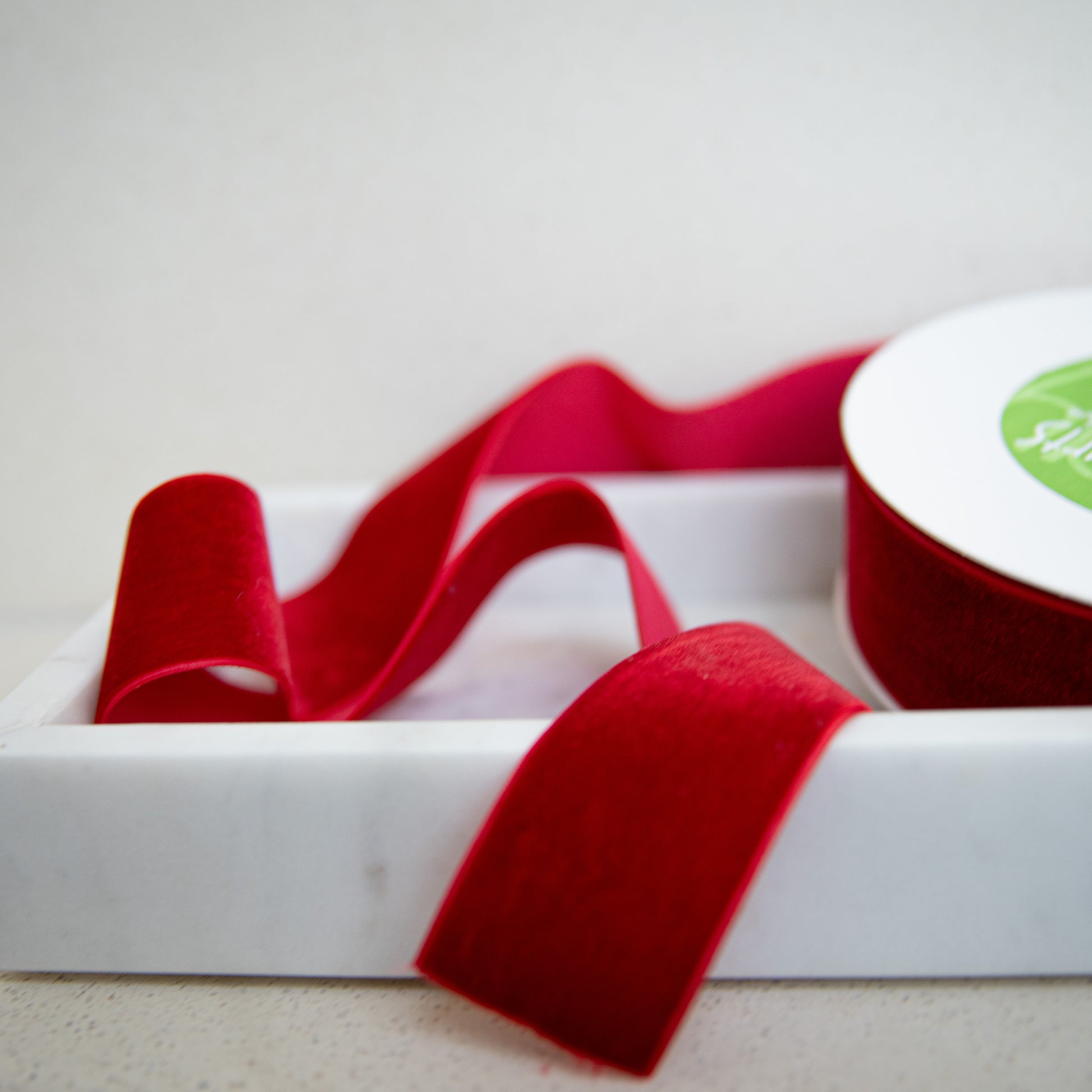 Red ribbon on a white box with a white background