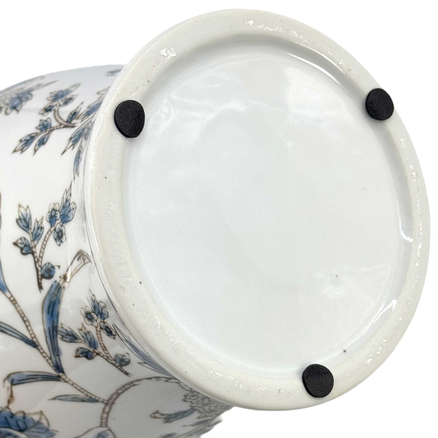 Close-up of a ceramic vase with floral design and white lid on a white background