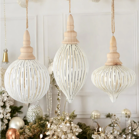 Decorative white hanging ornaments with wooden tops on a festive background.